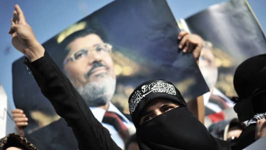 A woman protestor chants slogans in front of a poster of Egypt's ousted president Mohamed Morsi during a demonstration condemning the recent deadly military crackdown on pro-Morsi protesters in Cairo Saturday.